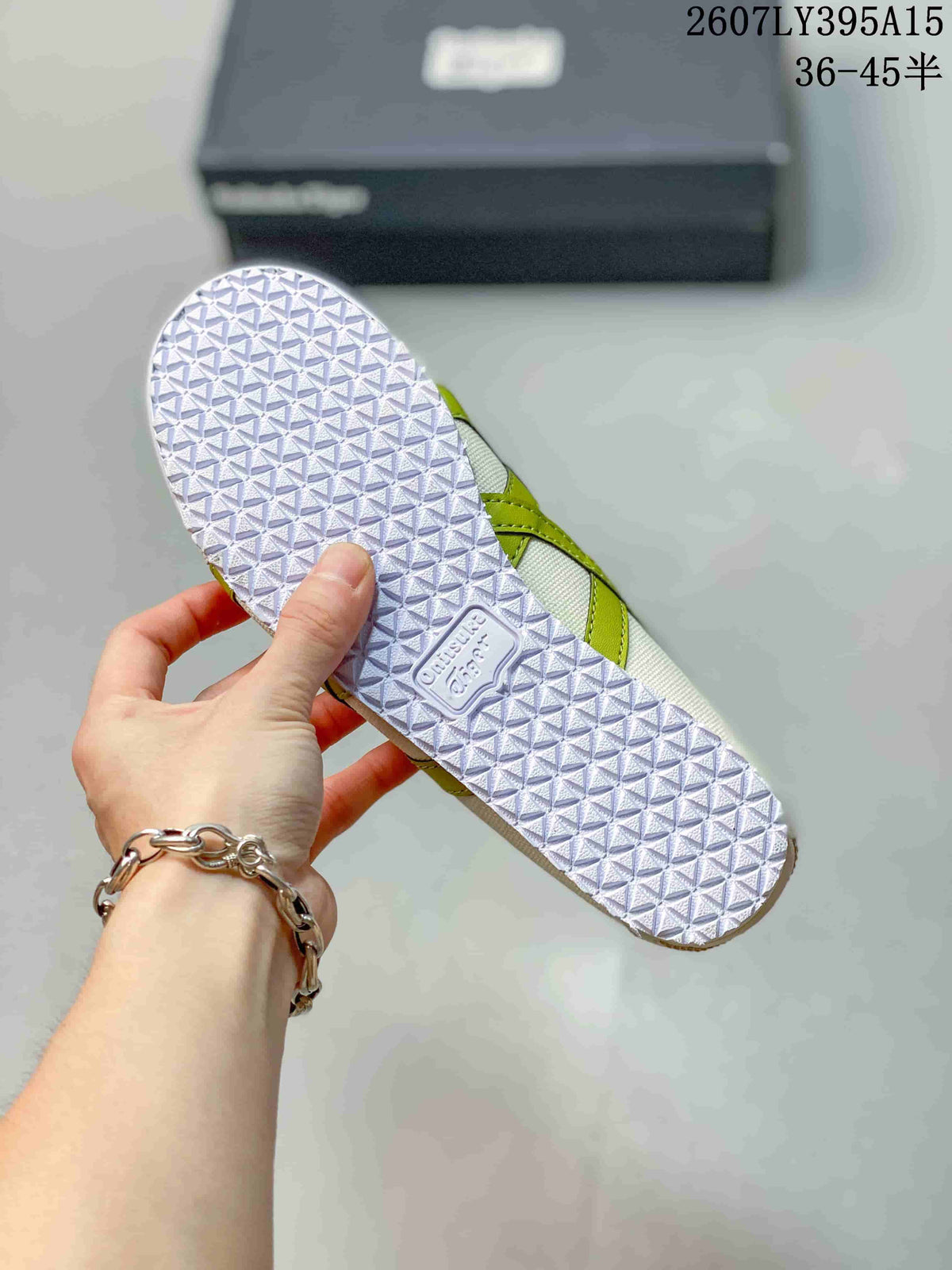 Bottom view of the sneaker showing the repeating geometric tread pattern on the rubber outsole.