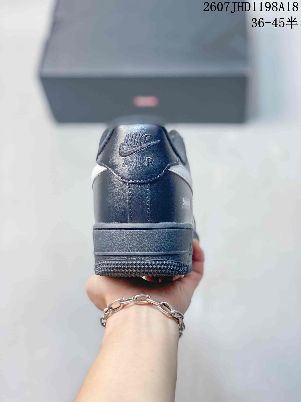 Rear view of a black low-top sneaker showing the padded heel collar, heel branding, and layered rubber outsole; image text shows style code 2607JHD1198A18 and sizes 36–45.5.
