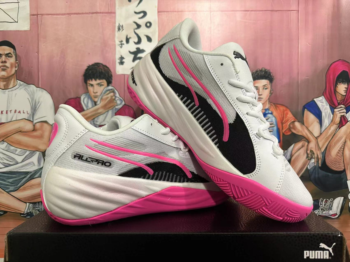 Pair of white PUMA All-Pro shoes with black and pink side graphics and pink outsoles.