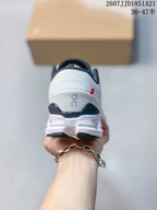 Rear view of the white sneaker showing the padded heel, dark heel detail, On branding, and small red accent.