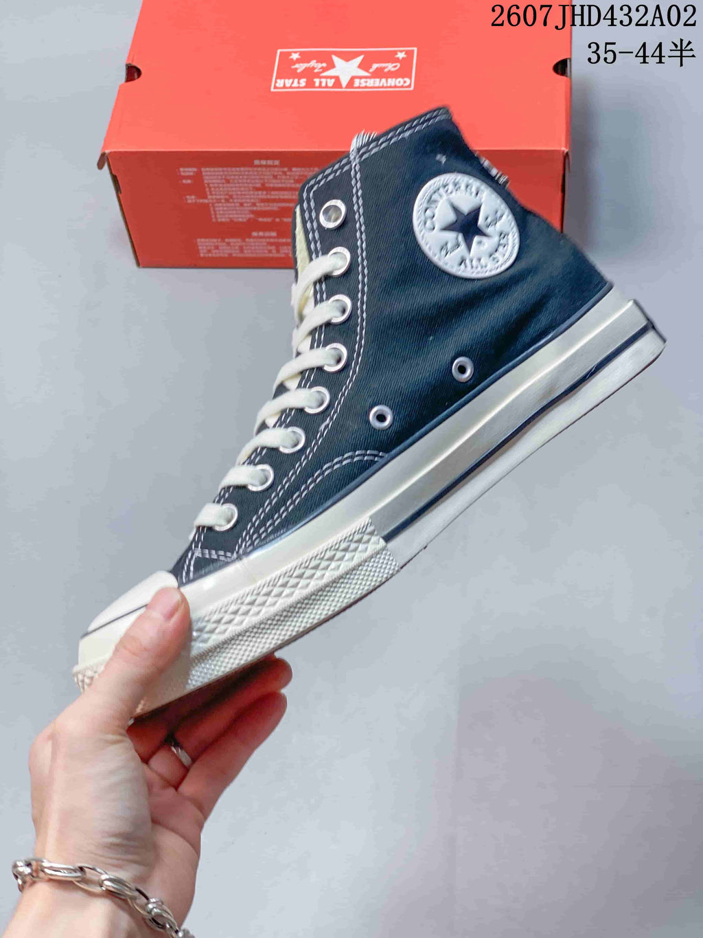 Side view of a navy high-top sneaker with a round ankle patch and white sole