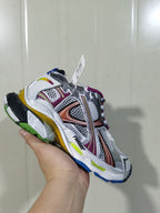 Close-up view of a metallic multicolor Balenciaga Runner sneaker showing layered panels, mesh-style sections, contrasting overlays, and a multicolor outsole.