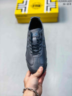 Top view of the black sneaker showing the rounded toe, black laces, tongue label, and contrast stitching.