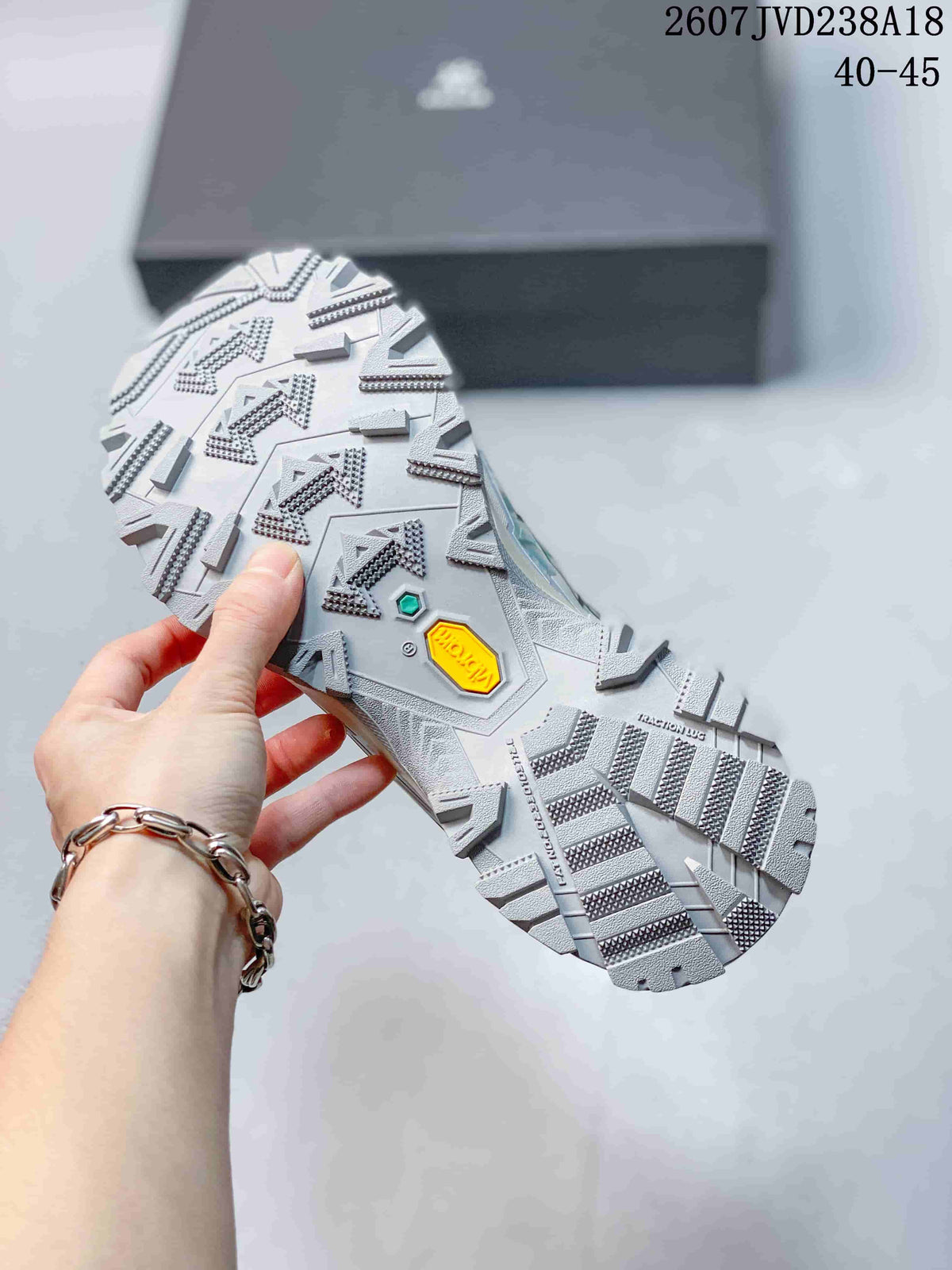 Close-up of the hiking shoe outsole showing a deep lug pattern, directional tread, and visible Vibram marking; size range 40–45 and code 2607JVD238A18 are overlaid.