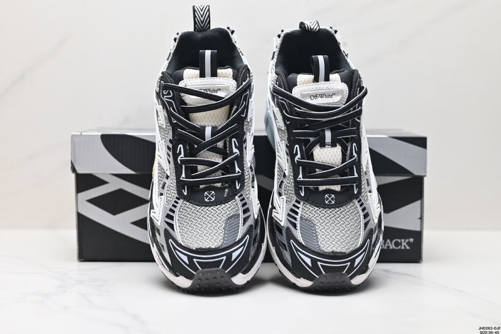 Front view of the paired sneakers showing black laces, grey mesh panels, and layered directional graphics.