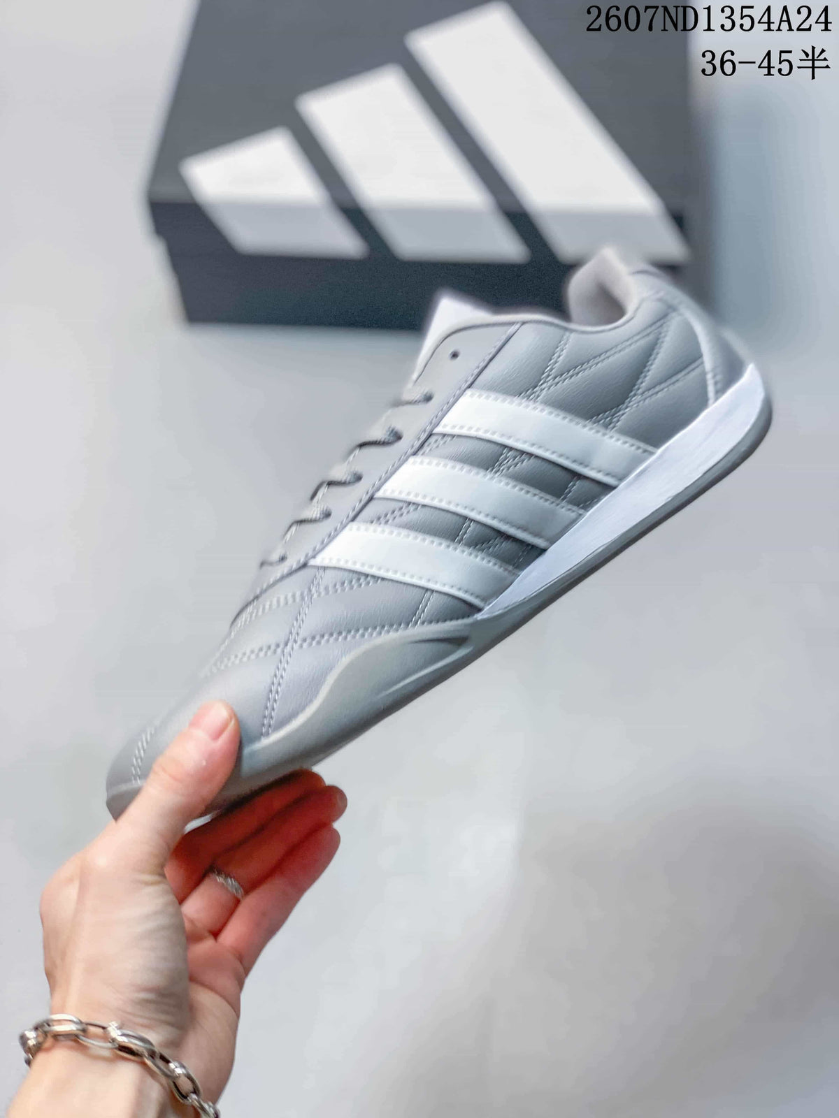 Side profile of the gray low-top sneaker with three white stripes and a white midsole.