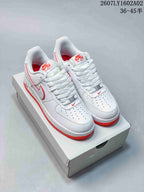 Pair of white Nike Air Force 1 ’07 low-top sneakers with red accents, shown from above.