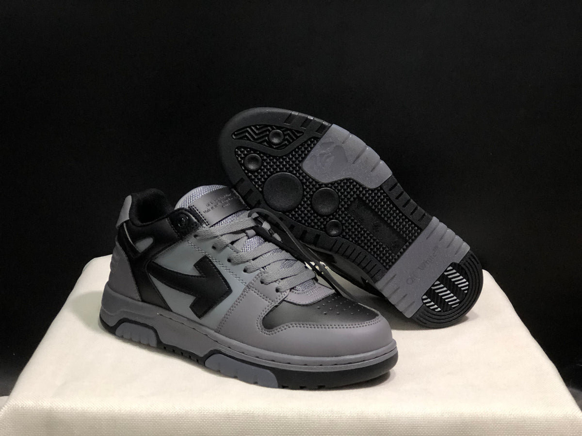 Angled view of the sneakers with one shoe lifted to reveal the patterned rubber outsole.