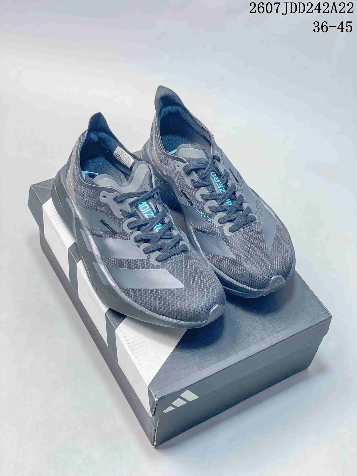 Pair of dark gray Y-3 Adios Pro 4 low-top sneakers displayed on a branded shoe box.