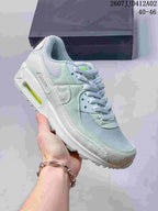 Angled side view of the pale blue and mint Nike Air Max 90 sneaker.