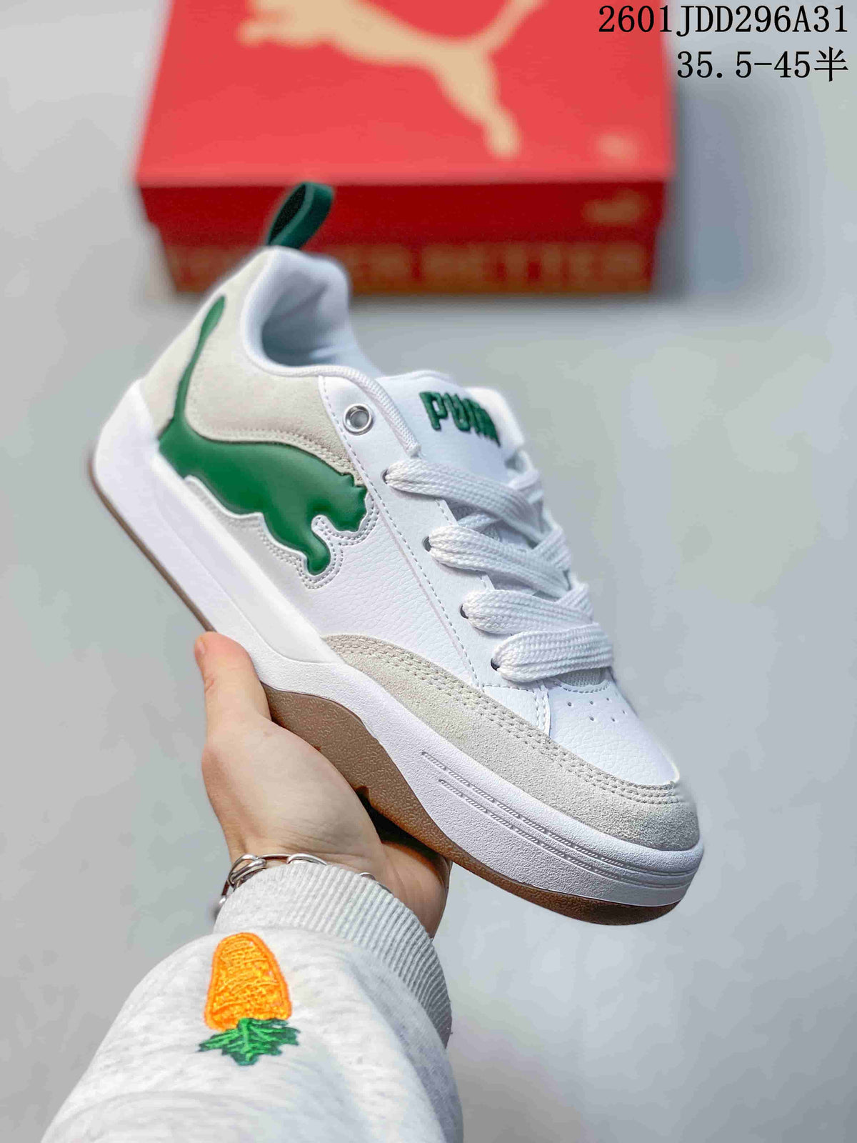 Side view of a white PUMA 180 sneaker with green side detail and a raised sole.