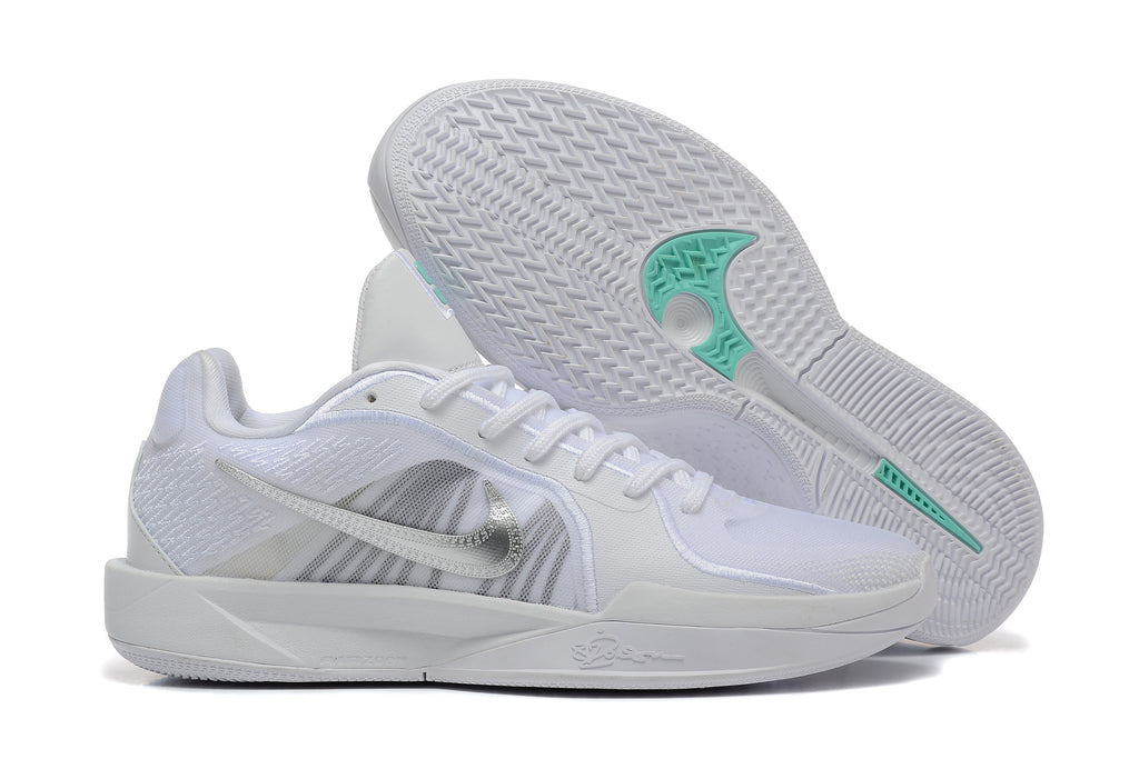 White basketball shoes with one shoe turned to show the patterned outsole and teal accents.