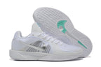 White basketball shoes with one shoe turned to show the patterned outsole and teal accents.