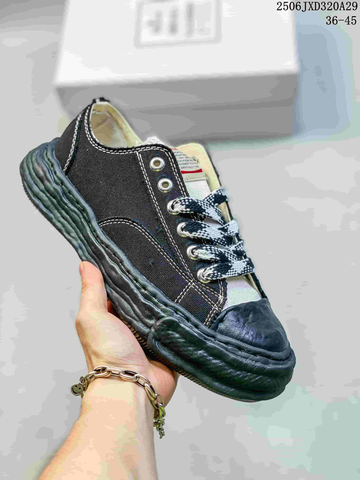 Angled side view of the black sneaker showing its canvas-like upper appearance, contrasting stitching and sculpted sole.