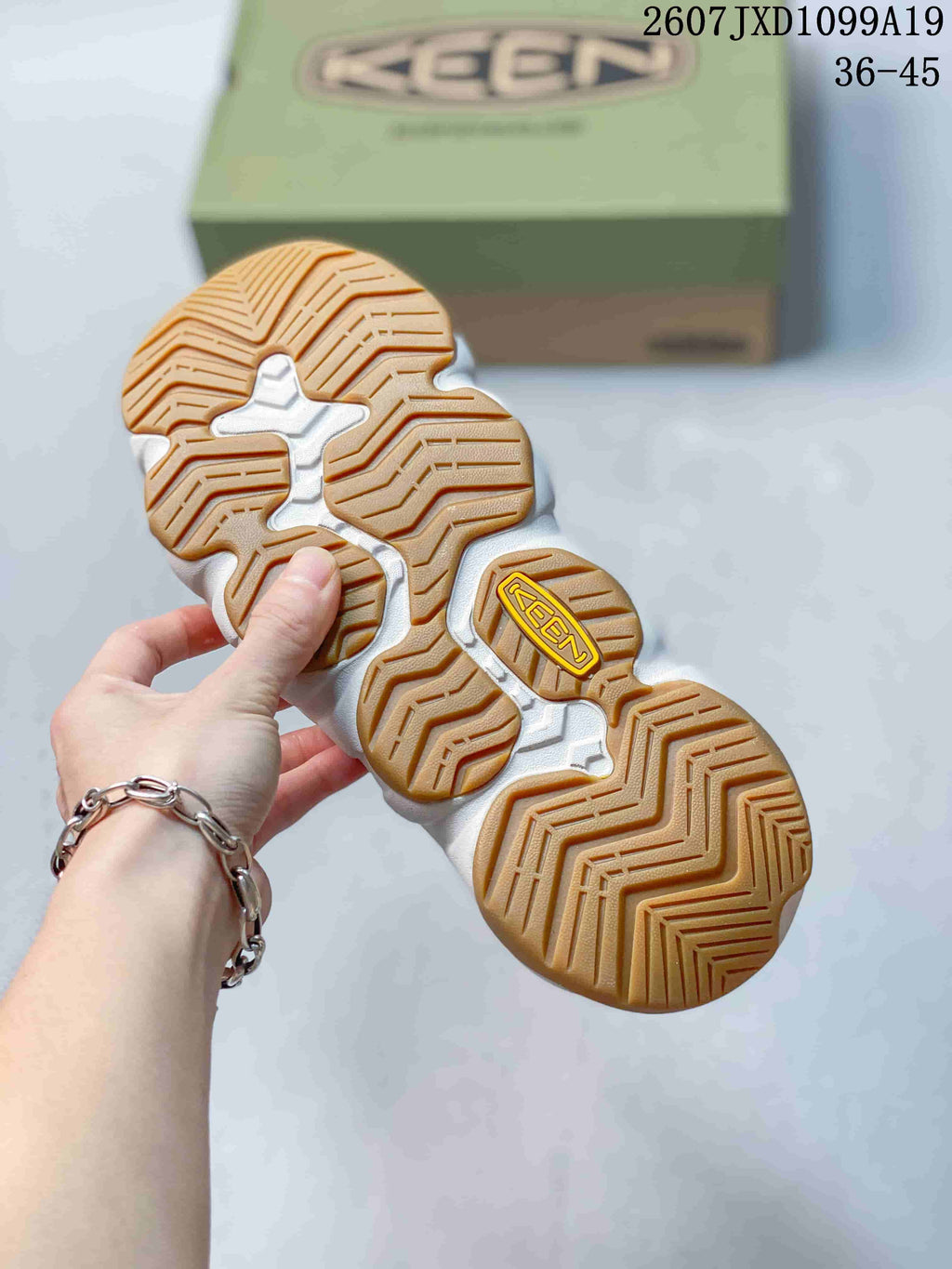 Underside view showing the tan lugged outsole and segmented tread pattern of the KEEN sandal.