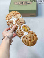 Underside view showing the tan lugged outsole and segmented tread pattern of the KEEN sandal.