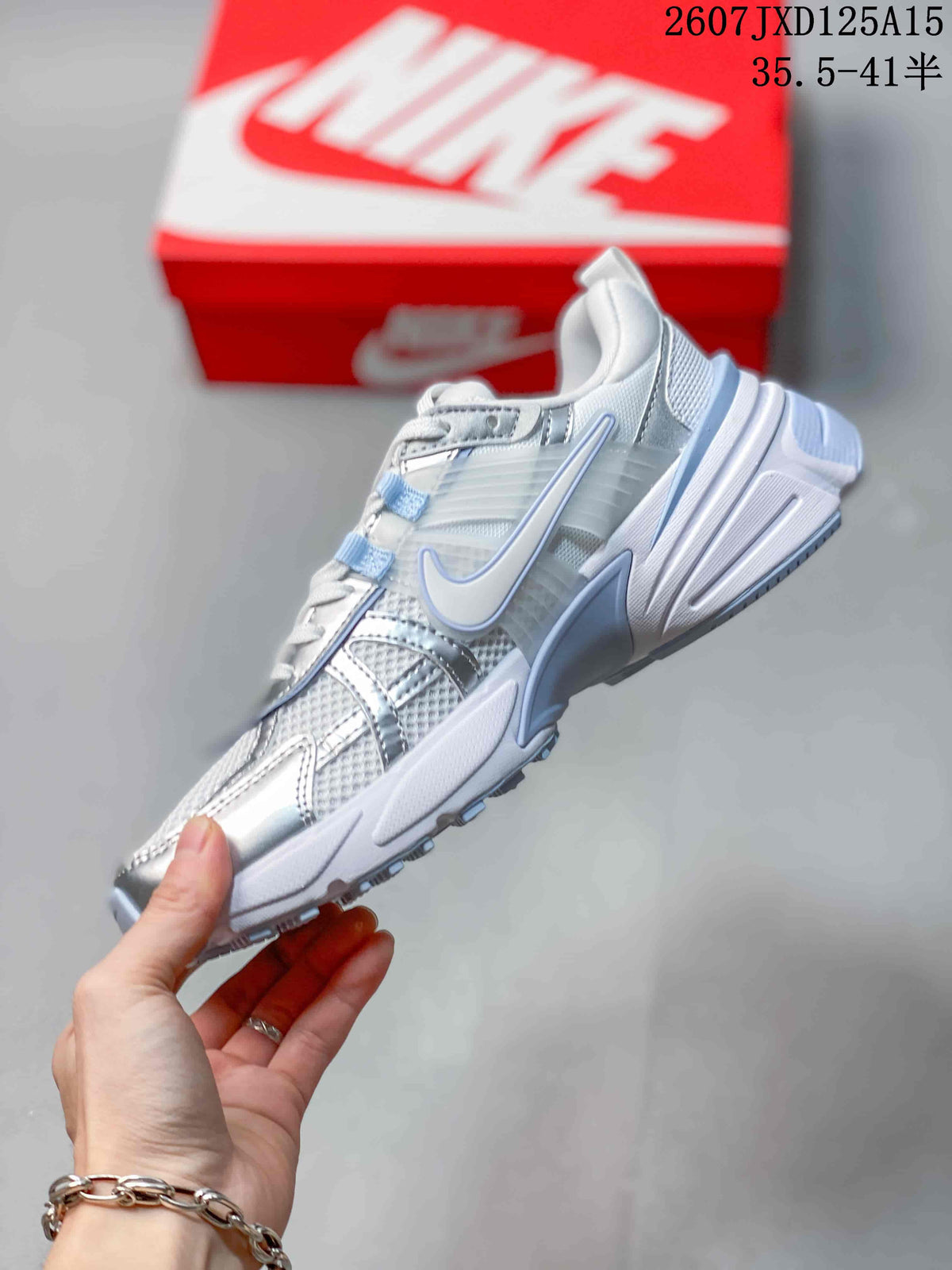 Side view showing the layered upper, mesh panels, silver overlays, and swoosh detail.
