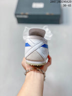 Rear view showing the white heel, blue stripe detail, and gum-colored outsole.