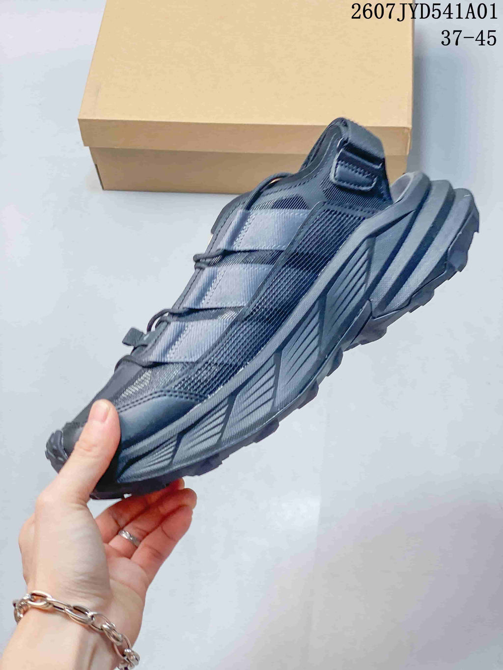 Side profile of a dark gray outdoor shoe with layered panels and rugged outsole