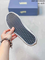 Close view of the sneaker outsole showing a dark waffle-pattern tread and white rubber sidewall.