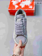 Top view of the gray lace-up sneaker showing the tongue label, eyelets, laces, and textured toe area.