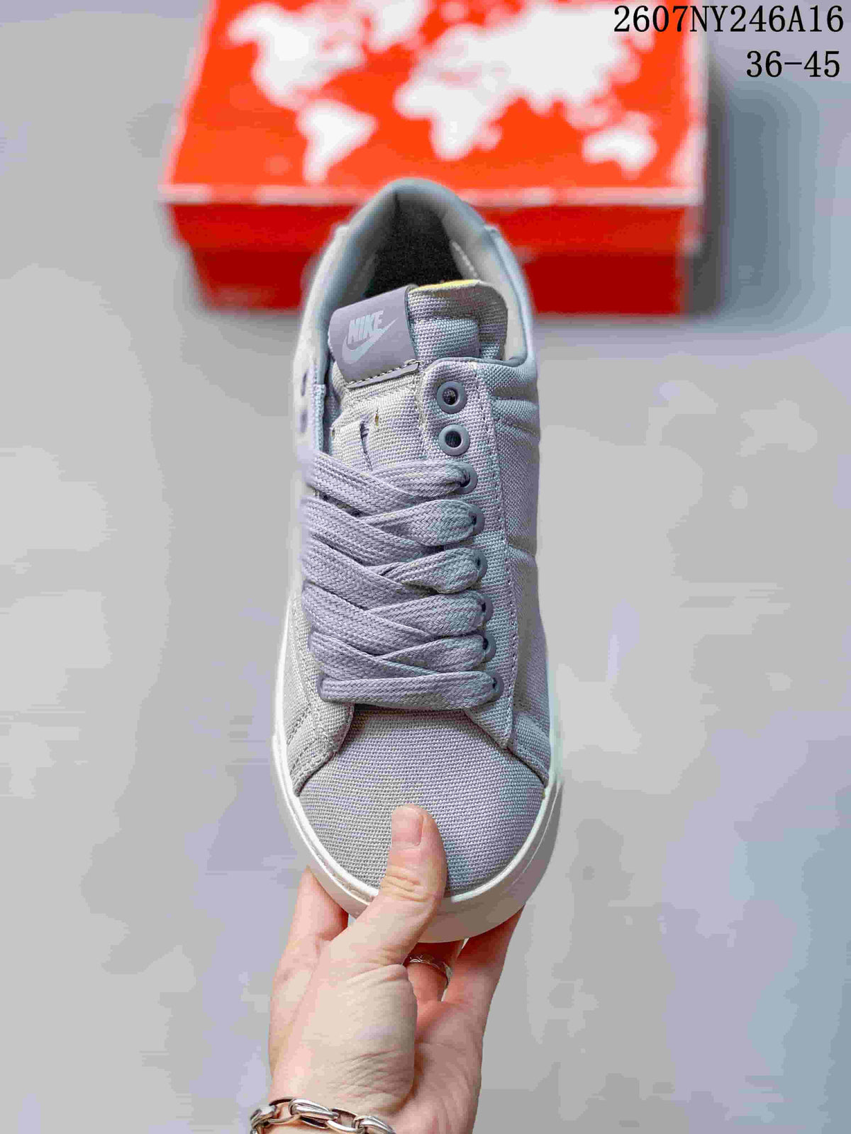 Top view of the gray lace-up sneaker showing the tongue label, eyelets, laces, and textured toe area.