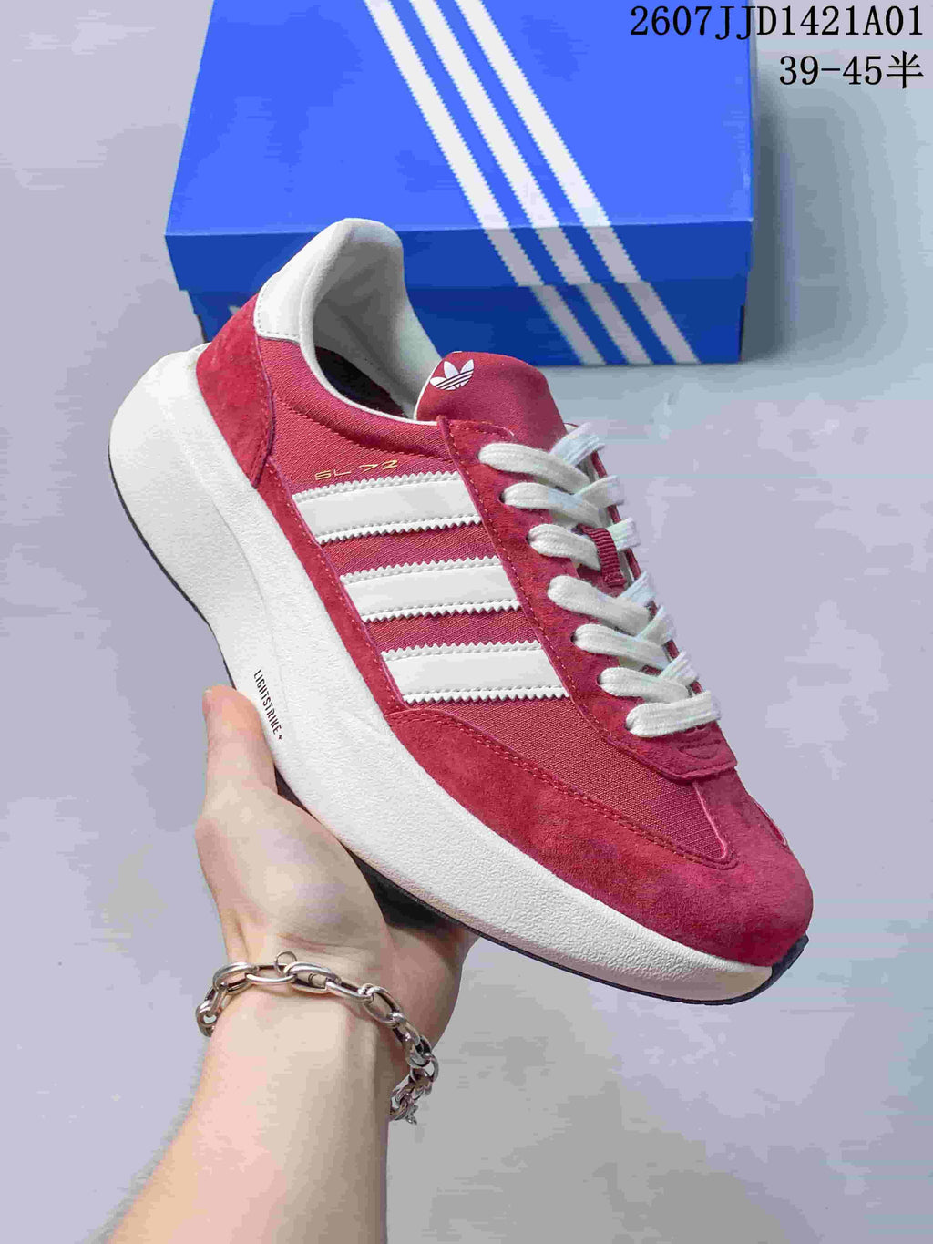 Angled side view of the red Adidas Adizero SL 72 Pro sneaker, showing the SL 72 lettering, white stripes, and thick sole.