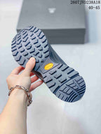 Underside view of a dark gray hiking shoe showing a deep lugged outsole and visible Vibram mark.