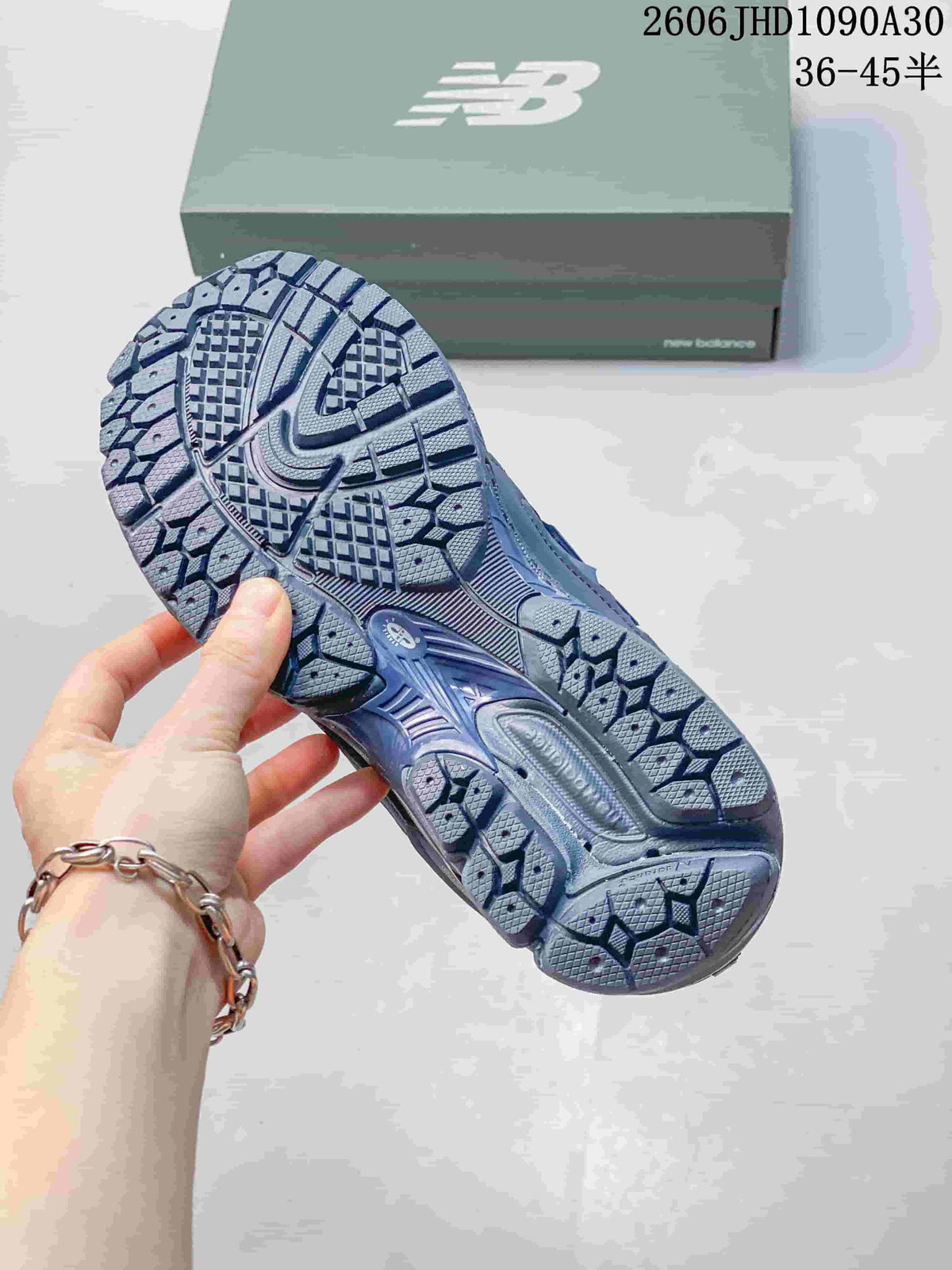 Close-up of the patterned outsole on a blue-gray New Balance sneaker.