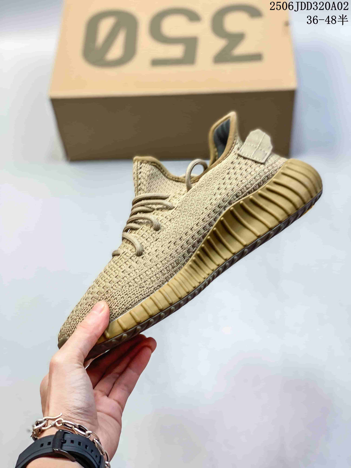 Side profile of a beige Adidas Yeezy Boost 350 sneaker showing the knit upper, tonal laces, side stripe, and ribbed outsole.