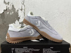 Pair of gray Converse trainer-style sneakers with white side details and gum-colored soles