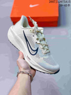 Angled view of a white Nike Quest 6 sneaker with a dark side mark and perforated upper.