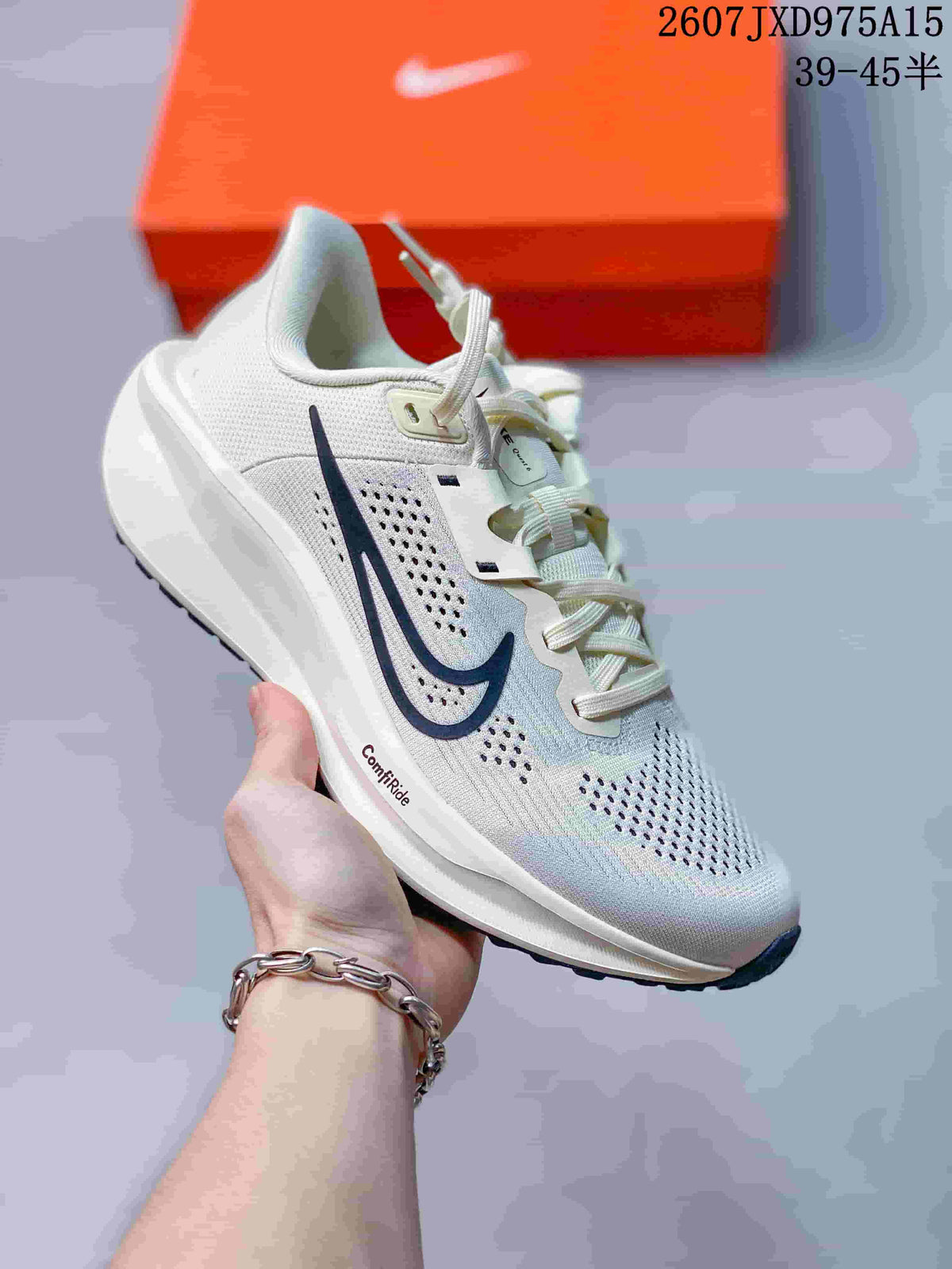 Angled view of a white Nike Quest 6 sneaker with a dark side mark and perforated upper.