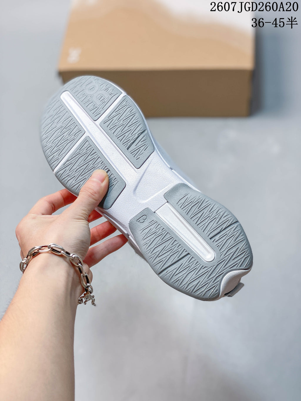 Close view of the sneaker outsole showing segmented textured tread areas and a light gray finish.