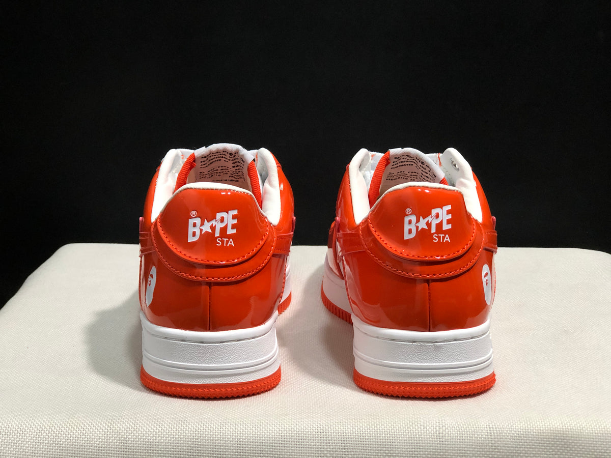 Rear view of the pair showing BAPE Sta branding on the orange heel panels.