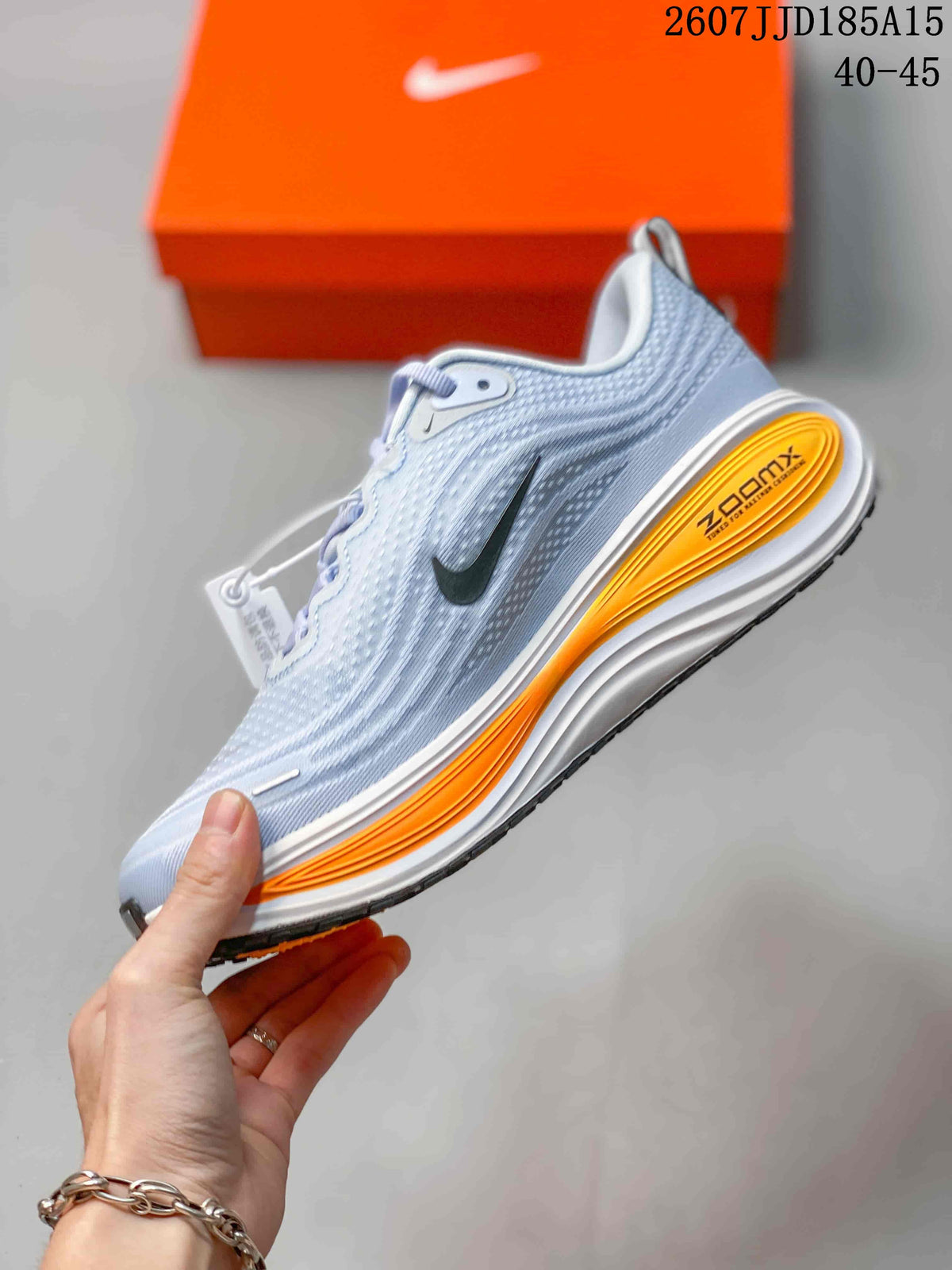 Side view highlighting the Nike Swoosh, textured upper, orange midsole accents, and sculpted sole.