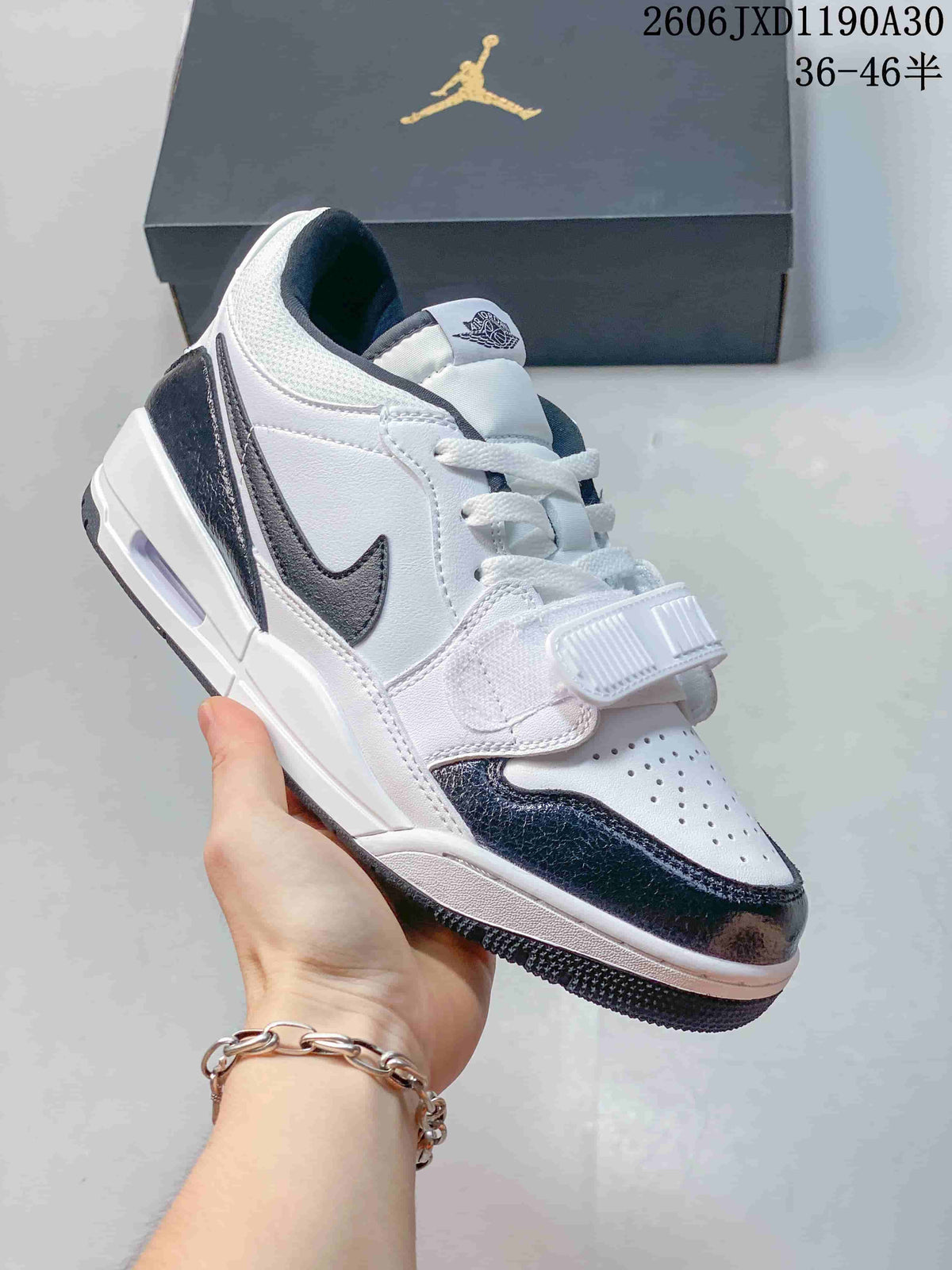 Angled side view of a white and dark Jordan Legacy 312 Low sneaker