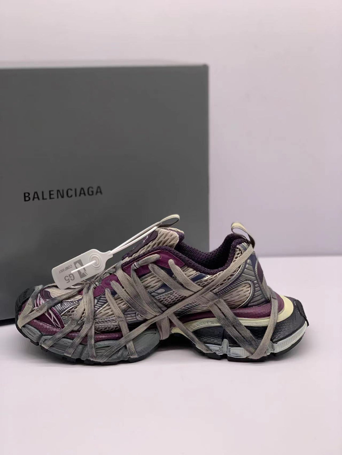Opposite side view showing the layered gray and purple sneaker panels, oversized laces, and textured outsole.