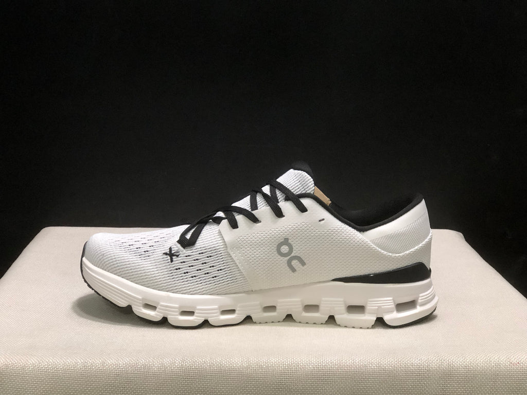 Side profile of an Ivory and Black On Cloud X4 sneaker with a layered white outsole.