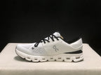 Side profile of an Ivory and Black On Cloud X4 sneaker with a layered white outsole.