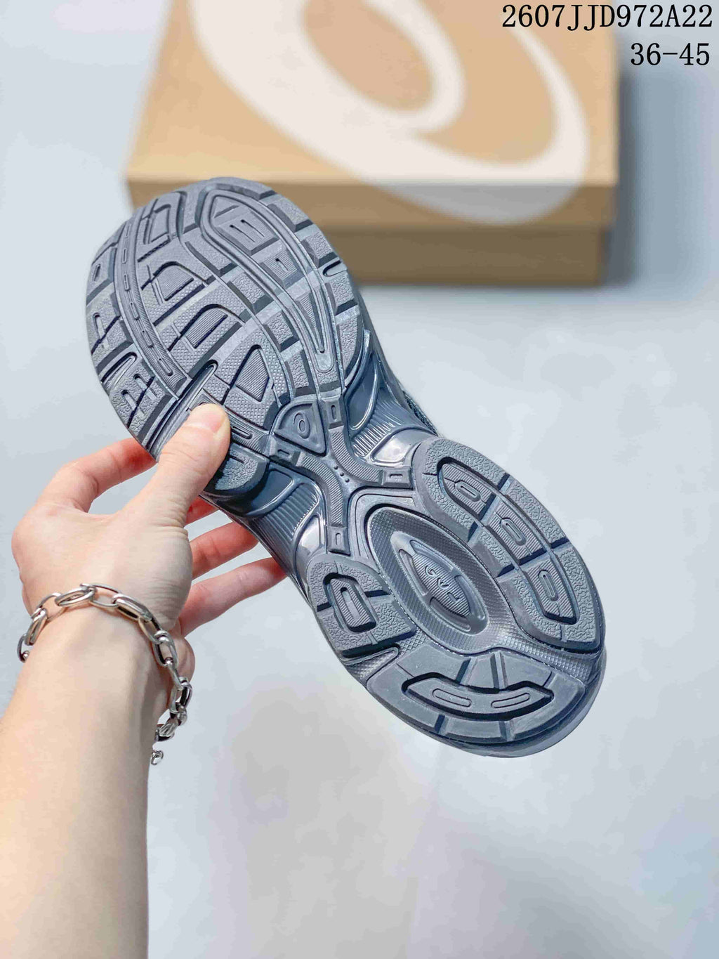 Close-up of the patterned outsole showing textured tread sections on an ASICS sneaker.