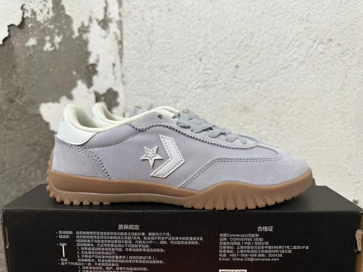 Side view showing the white star-and-chevron detail on a gray Converse sneaker