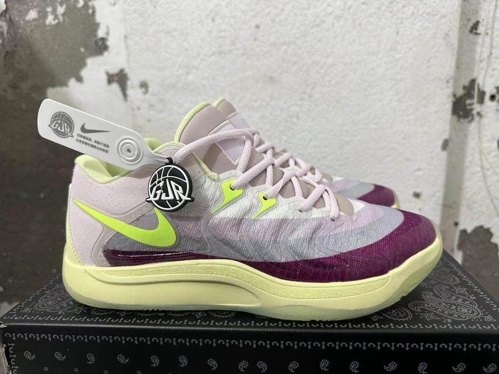 Side view showing the Nike swoosh and white, purple, and pale lime color blocking.