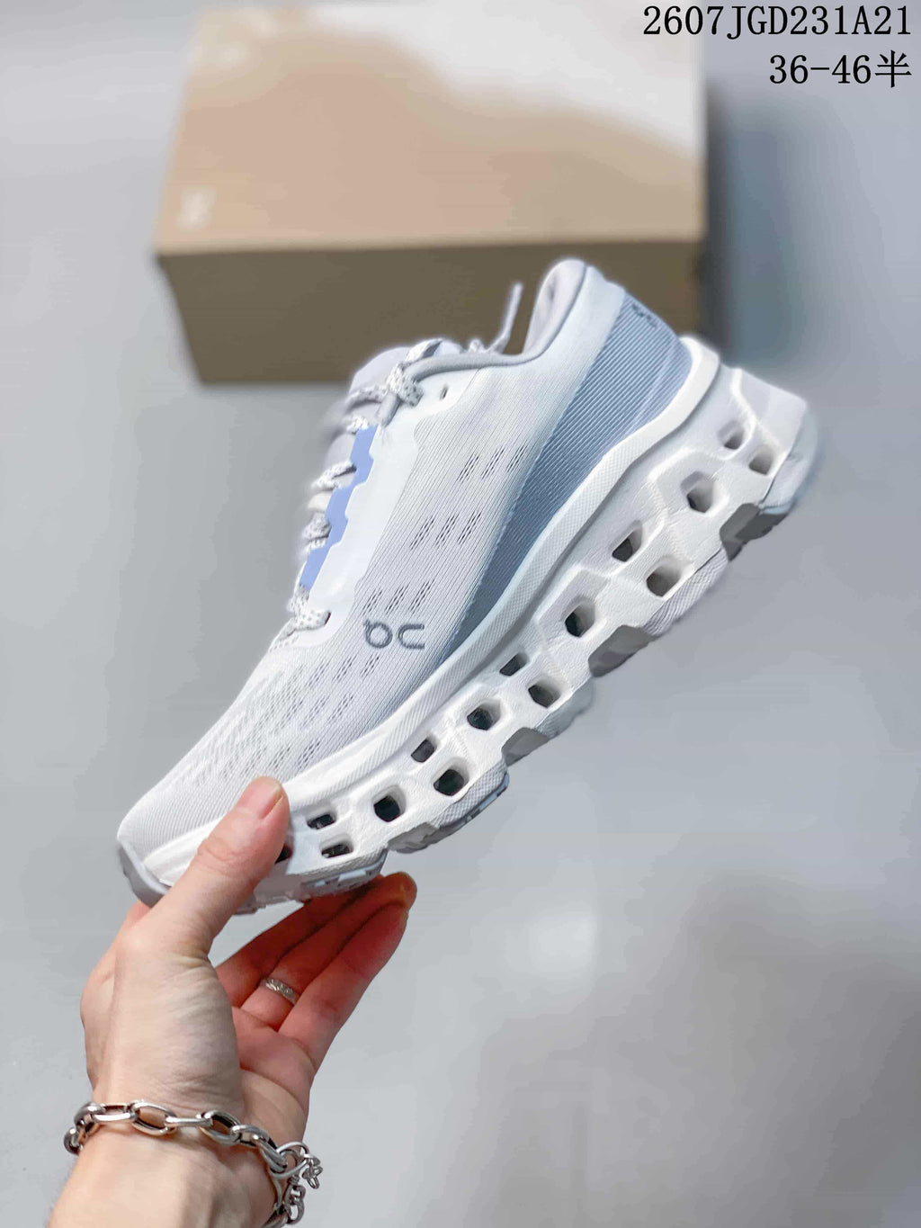 Side view highlighting the pale upper, On branding, and segmented sole openings.