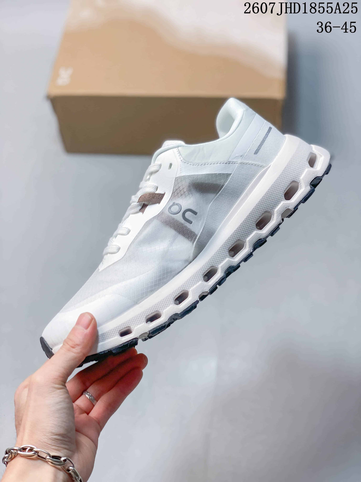Side view of the white and light gray sneaker showing the On logo, layered upper, sculpted midsole, and outsole cutouts; overlay text shows style code 2607 JHD1855A25 and size range 36-45.