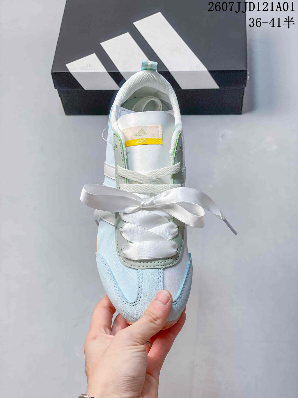 Top view of a pale blue and white adidas JOG 2.0 sneaker with ribbon-style laces