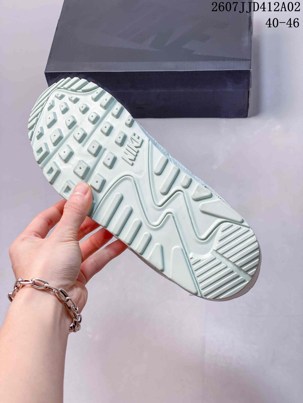 Close-up of the patterned outsole on a pale-colored Nike Air Max 90 sneaker.