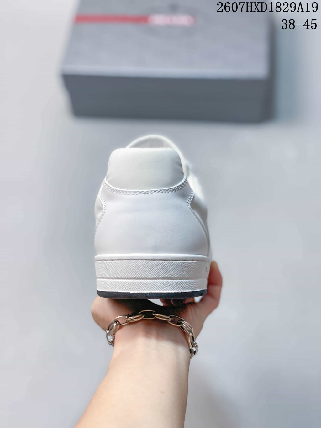 Rear view of the white low-top sneaker showing the heel counter, stitching and layered white sole.