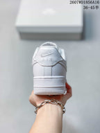Rear view of the white low-top sneaker showing the heel tab with Nike and AIR branding and the raised outsole.