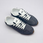 Top three-quarter view showing both carbon gray sneakers, white laces, and branded tongues.